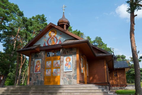Orthodox wooden church with icons on the façade, surrounded by trees, Orthodox Church of the
