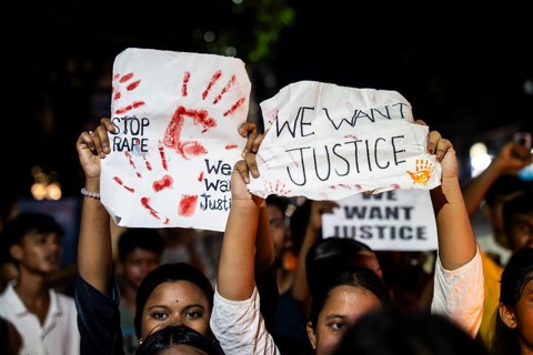 Students holds placard and shout slogans as they participate in a protest against the rape and