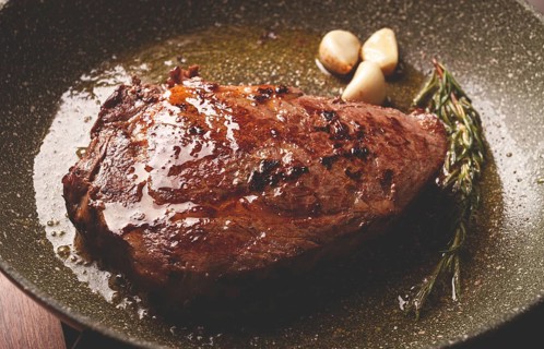 Fried steak, beef steak, rib eye steak, in a frying pan, top view, no people