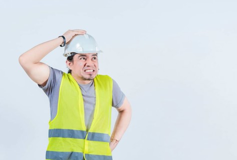 Constructor worker in problems holding head isolated. Worried builder engineer holding head.