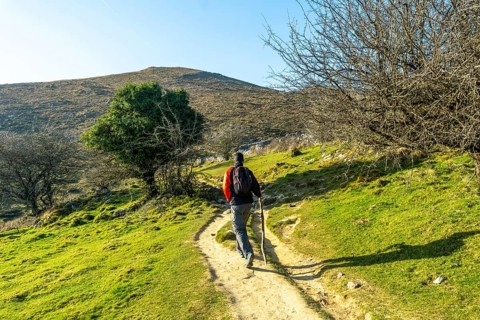 A man walking on the path climbing to the top of Mount Ernio or Hernio in Gipuzkoa, Basque Country