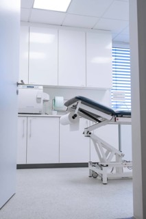 Sterile practice room with treatment couch and paper roll, modern equipment, Urology, Germany