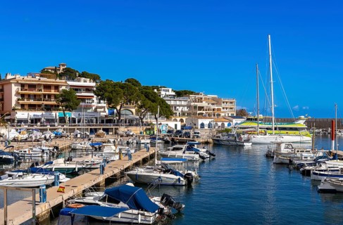 Boats and motor yachts in the small harbour of Cala Rajada, Majorca, Spain