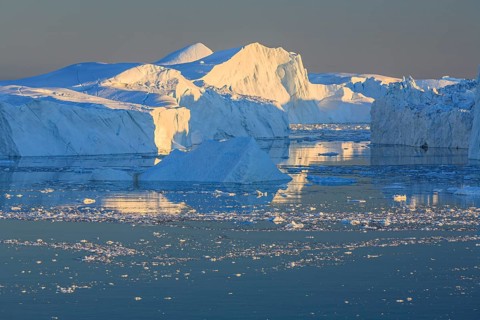 Icebergs and ice floes reflected in the water, summer, midnight sun, Jakobshavn glacier and ice