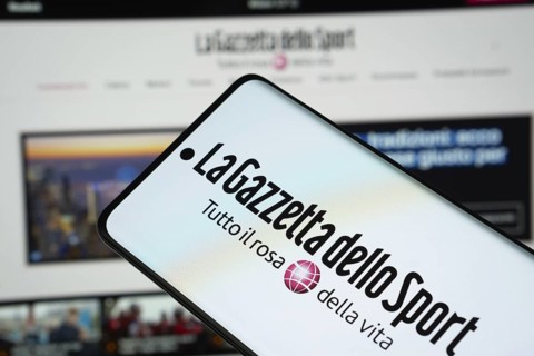 The logo of the newspaper la gazzetta dello sport is displayed on a smartphone screen, and the