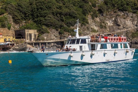 White shuttle service boat arriving in bay in late summer, Monterosso village, Cinque Terre, La