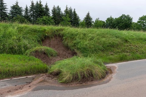 Symbolic image of climate change, slippery slope on a country road after heavy rainfall, near