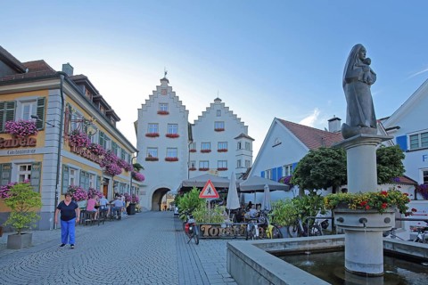 Fountain with Madonna figure, street pub and historic gate castle with stepped gable, town gate,