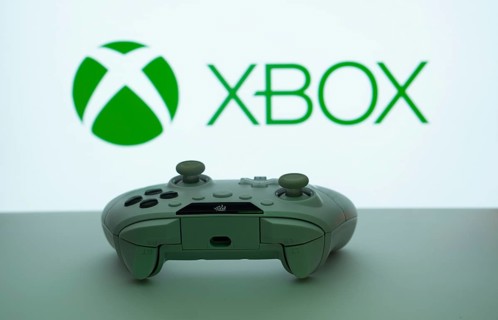 Dhaka, Bangladesh- 09 May 2025: A close-up of a white gamepad with the XBOX seen on screen in the