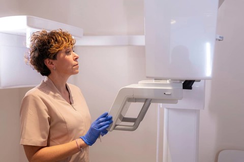 Assistant in the x-ray room preparing an x-ray of a client in the modern dental clinic