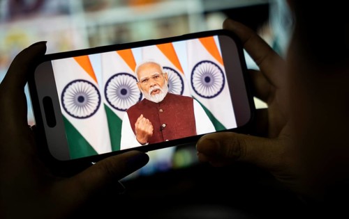 A person watches PM Narendra Modi's address to the nation after Operation Sindoor, on a mobile