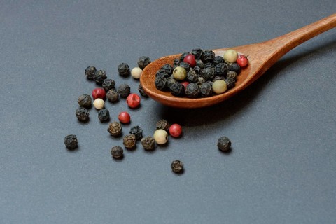 Pepper, various peppercorns in a wooden spoon