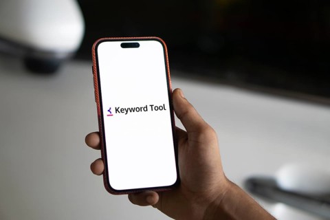 keyword tool logo is displayed on smartphone. Keyword Tool is a free online keyword research tool