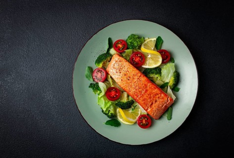 Grilled salmon fillet, with vegetables, broccoli, cherry, iceberg lettuce, spices and herbs,