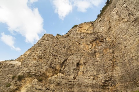 Low angle view of rugged and steep cliff with cut rock face, Sorrento, Campania region, Italy