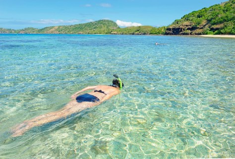 Snorkeller swimming in Fiji islands turquoise clear water, Drawaqa Island, Yasawa islands, Fiji