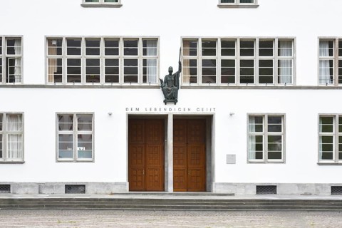 Heidelberg, Germany, April 2019: Front of main building of Ruprecht-Karls-University with statue of
