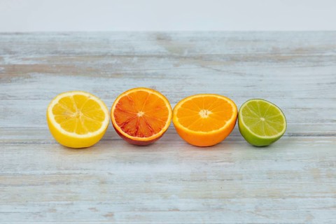 Row of half oranges, lemons and limes on a table