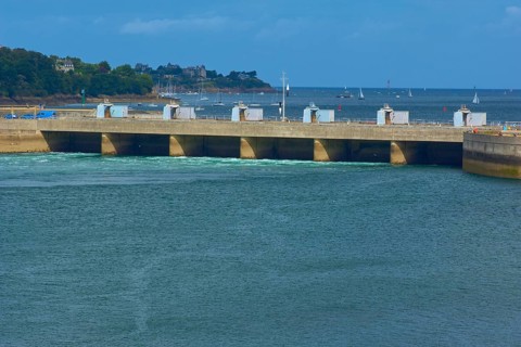Rance tidal power station and a wooded coastline under a blue sky, La Rance, Saint-Malo, La