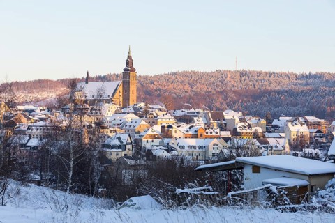 Winter town view with St Wolfgang's Church and Gleesberg in the evening light, Schneeberg in the