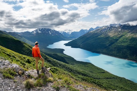 Mountaineer enjoys views of blue lake and mountains on Twin Peaks Trail, Eklutna Lake, Chugach