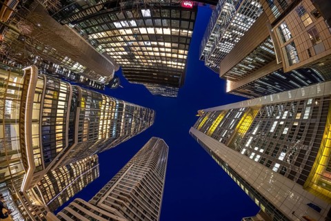 The glowing skyscrapers of Frankfurt's banking skyline rise into the blue evening sky, Frankfurt am