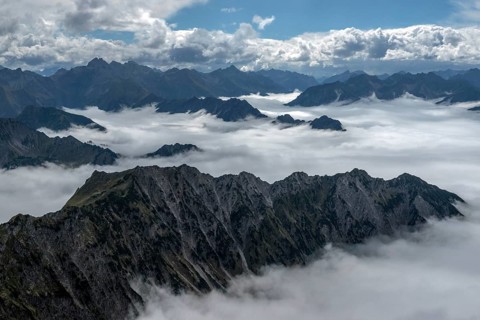 View from the Nebelhorn summit to mountains of the Allgäu Alps, mountains rising from fog in the