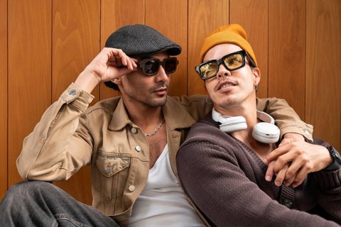 A Colombian gay couple enjoying a relaxed moment together. They wear fashionable clothes,