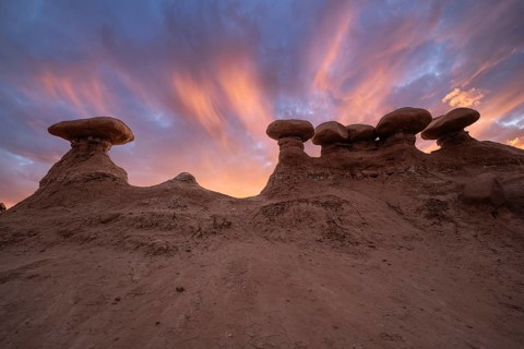 Captivating sandstone formations in Goblin Valley State Park, Utah, glow under a dramatic sunset