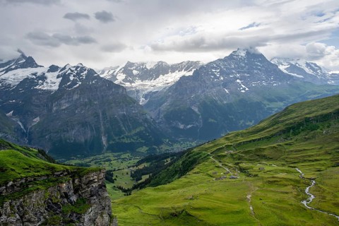 View of mountain landscape with green meadows and alpine huts Bachlager, Grindelwald First,