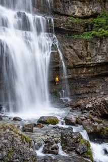 Adventure, Little hiker under large Cascata di Mezzo waterfall, long exposure, Vallesinella,