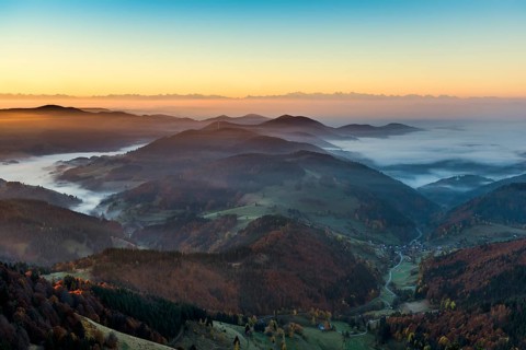 View from Belchen heading south of Wiesental and the Swiss Alps, morning atmosphere with fog in