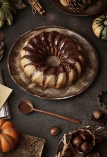 From above tasty appetizing pumpkin cake with chocolate cream on table decorated with autumn