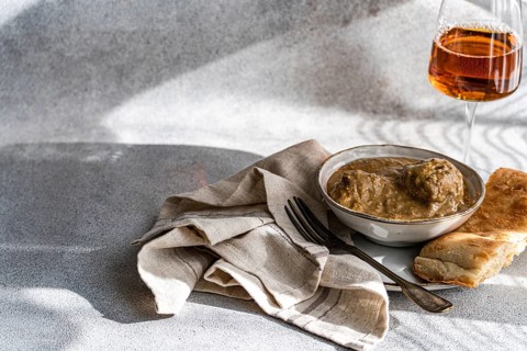 A bowl of satsivi, the renowned Georgian chicken in walnut sauce, paired with freshly baked bread