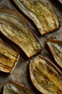 Close-up view of oven roasted eggplant slices seasoned with Mediterranean spices. Perfect for a