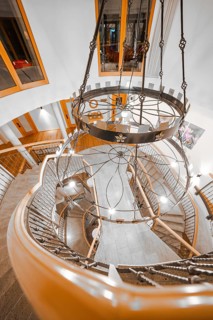View from above of an elegant staircase with chandelier and wooden banister, Hotel Krone Lamm,