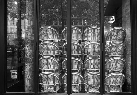 Chairs stacked in front of the window in a restaurant, black and white, Paris, France