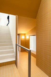 Contemporary stairway featuring vibrant yellow tiles, walls and ceiling for an eye-catching design.