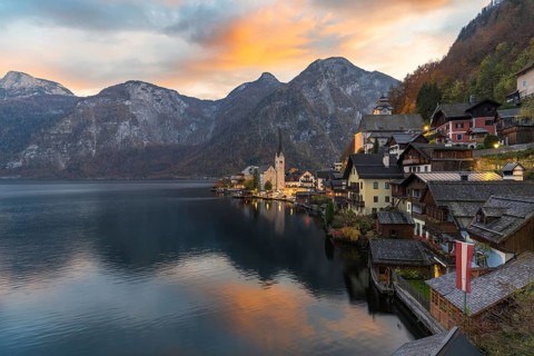Charming view of Hallstatt village nestled between a serene lake and majestic mountains Warm sunset