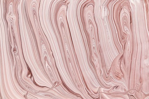 This abstract image features elegant acrylic paint beige and pink swirls. The flowing lines and