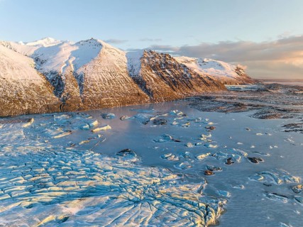 A breathtaking aerial view of Skaftafell's Glacier, showcasing its icy expanse amidst snow-capped