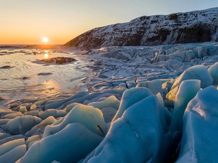 Captivating sunrise in Skaftafell, Iceland, featuring glowing icebergs with a stunning backdrop of