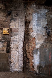 Rough and textured wall with varying materials showcasing urban decay and reconstruction. The mix