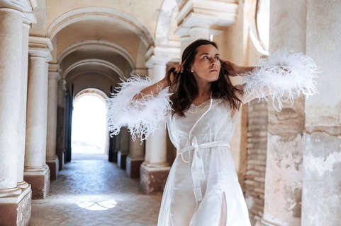 A bride stands gracefully in an ancient villa hallway in Treia, Macerata. The elegant setting with