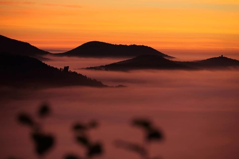 Orange landscape with mountains and clouds of fog in front of sunrise, nature photography, blue