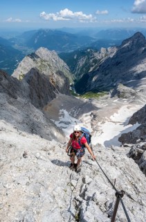 Mountaineer with helmet in a secured via ferrata, Zugspitze via ferrata, ascent to the Zugspitze,
