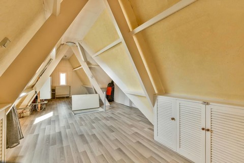 An inviting modern A-frame interior featuring wooden beams and a spacious layout. The aesthetic
