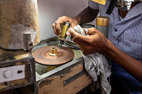 Grinding machine in operation, with hands using tools for precise work, The gemstone cutters in the