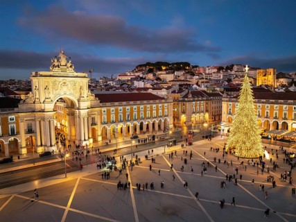 Praca do Comercio glows with festive Christmas lights and a tall tree during a winter evening in