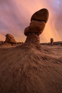 Towering sandstone formations illuminated by a serene sunset in Goblin Valley State Park, Utah. The